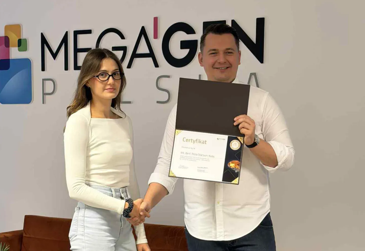 Wręczenie certyfikatu przed logo MEGAGEN POLSKA.